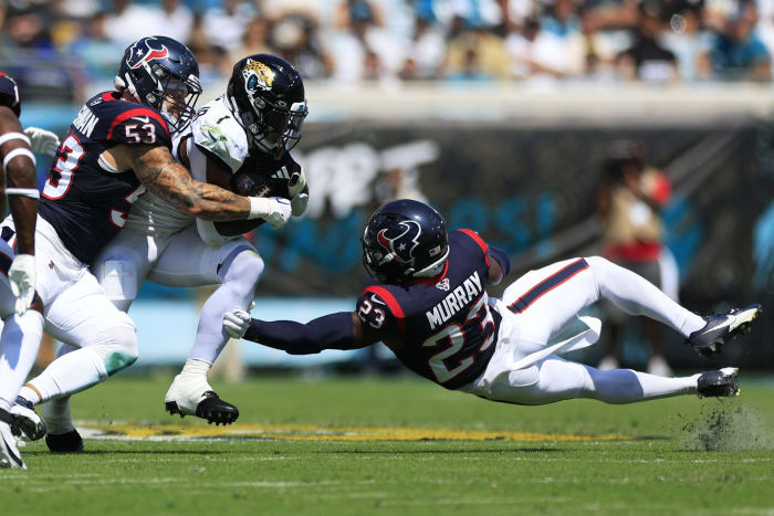 Jacksonville Jaguars running back Travis Etienne Jr. (1) rushes for yards against Houston Texans linebacker Blake Cashman (53) and safety Eric Murray (23) during the second quarter of an NFL football matchup Sunday, Sept. 24, 2023 at EverBank Stadium in Jacksonville, Fla. The Houston Texans defeated the Jacksonville Jaguars 37-17.